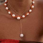 gold red and orange pearl necklace worn with seashells on beautiful brown skin