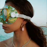 beautiful girl wearing gold gemstone earrings on the beach