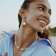 pearl and green gemstone necklace on smiling woman