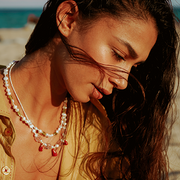 summer girl wearing pearl necklaces on the beach